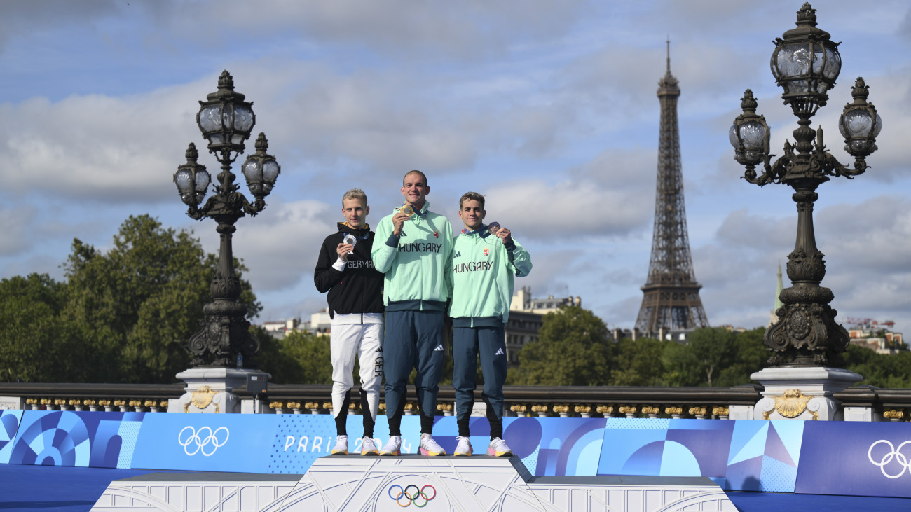 Az aranyérmes Rasovszky Kristóf (k), az ezüstérmes német Oliver Klemet (b) és a bronzérmes Betlehem Dávid (j) a férfi 10 kilométeres nyíltvízi úszás eredményhirdetésén a 2024-es párizsi nyári olimpián a Szajna III. Sándor hídjánál 2024. augusztus 9-én.