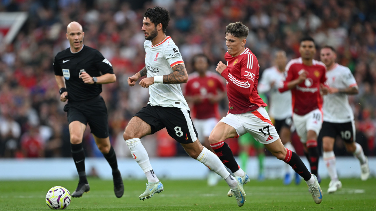 MANCHESTER, ENGLAND - SEPTEMBER 01: Dominik Szoboszlai of Liverpool runs with the ball under pressure from Alejandro Garnacho of Manchester United during the Premier League match between Manchester United FC and Liverpool FC at Old Trafford on September 01, 2024 in Manchester, England. (Photo by Shaun Botterill/Getty Images)