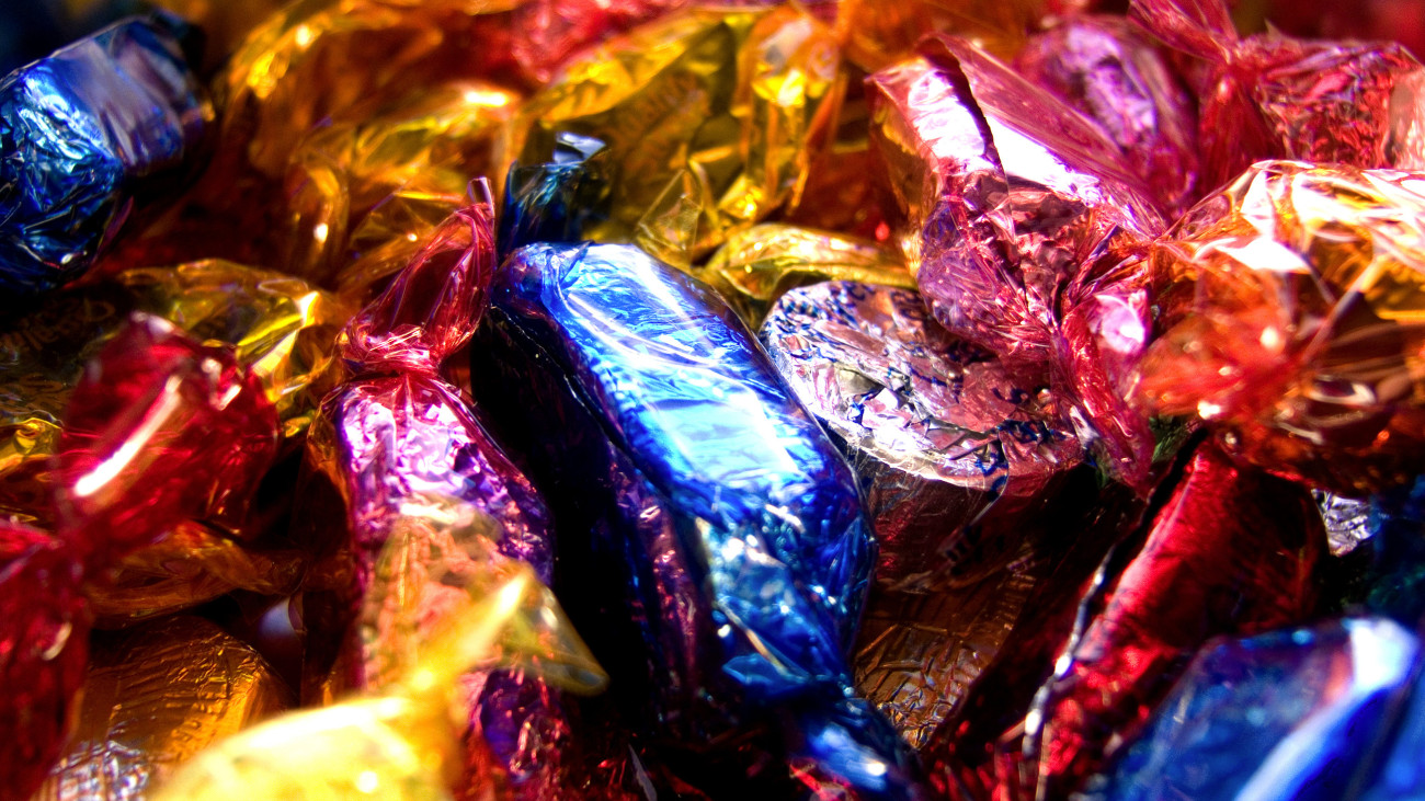 Close up of a box of colourfully wrapped chocolate sweets.