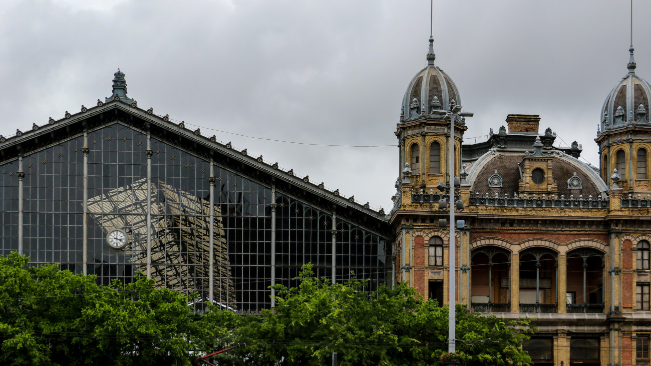 nyugati pályaudvar 2020 The decorative Budapest Nyugati railway station with its distinctive glass exterior front and white round clock face with black Roman numerals. The station was built by the Eiffel company in 1877.