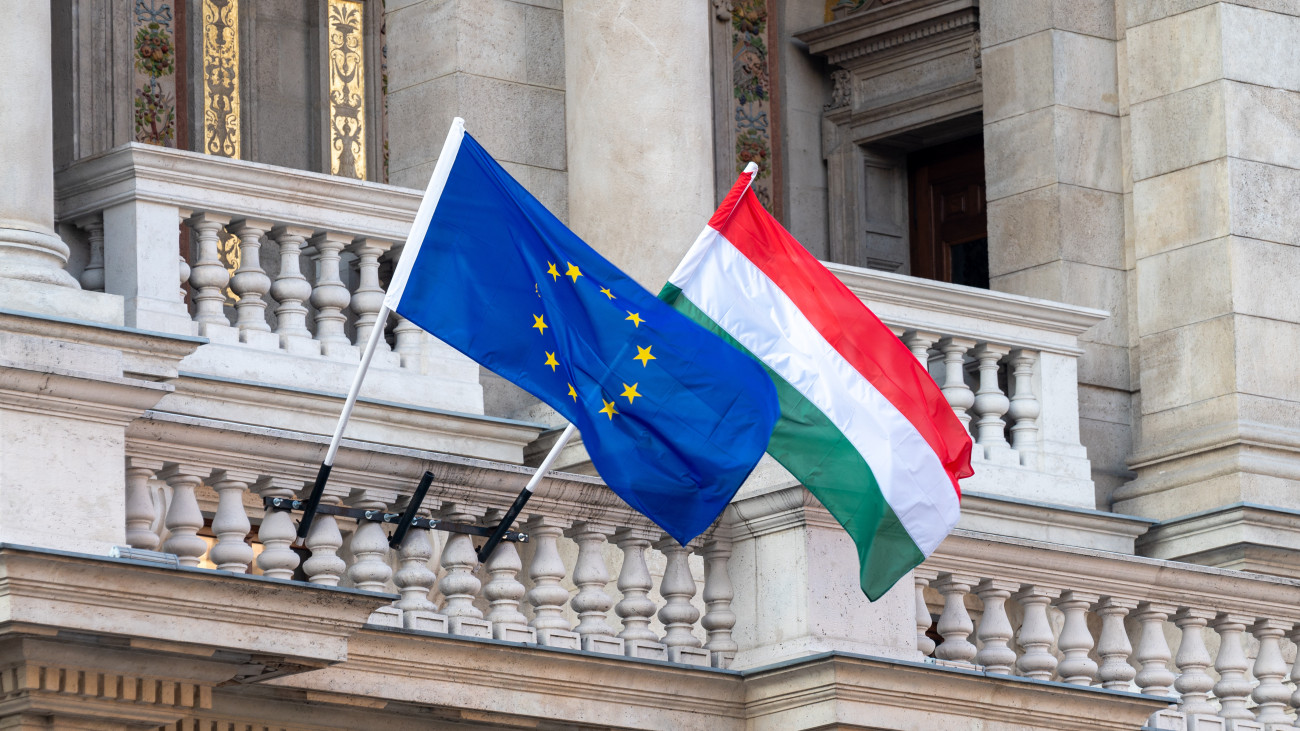 Flags of the European Union and Hungary flying from poles outside an ornate building in the centre of Hungarian capital city of Budapest