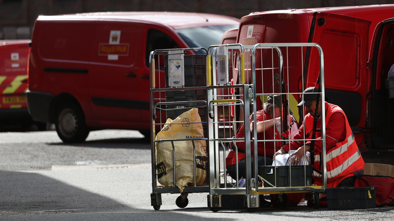 A brit királyi postaszolgálat (Royal Mail) két alkalmazottja rakodik a cég egyik telephelyén, a Buckinghamshire megyében lévő High Wycombe városban 2024. május 29-én. Ezen a napon Daniel Kretínsky cseh milliárdos megállapodott a Royal Mail tulajdonosával, hogy 1627 milliárd forintnyi angol fontért megvásárolja a szolgálatot. A Royal Mailt még VIII. Henrik király alapította 1516-ban, és több mint 500 éves története során a szolgálat most kerül először külföldi kézbe.