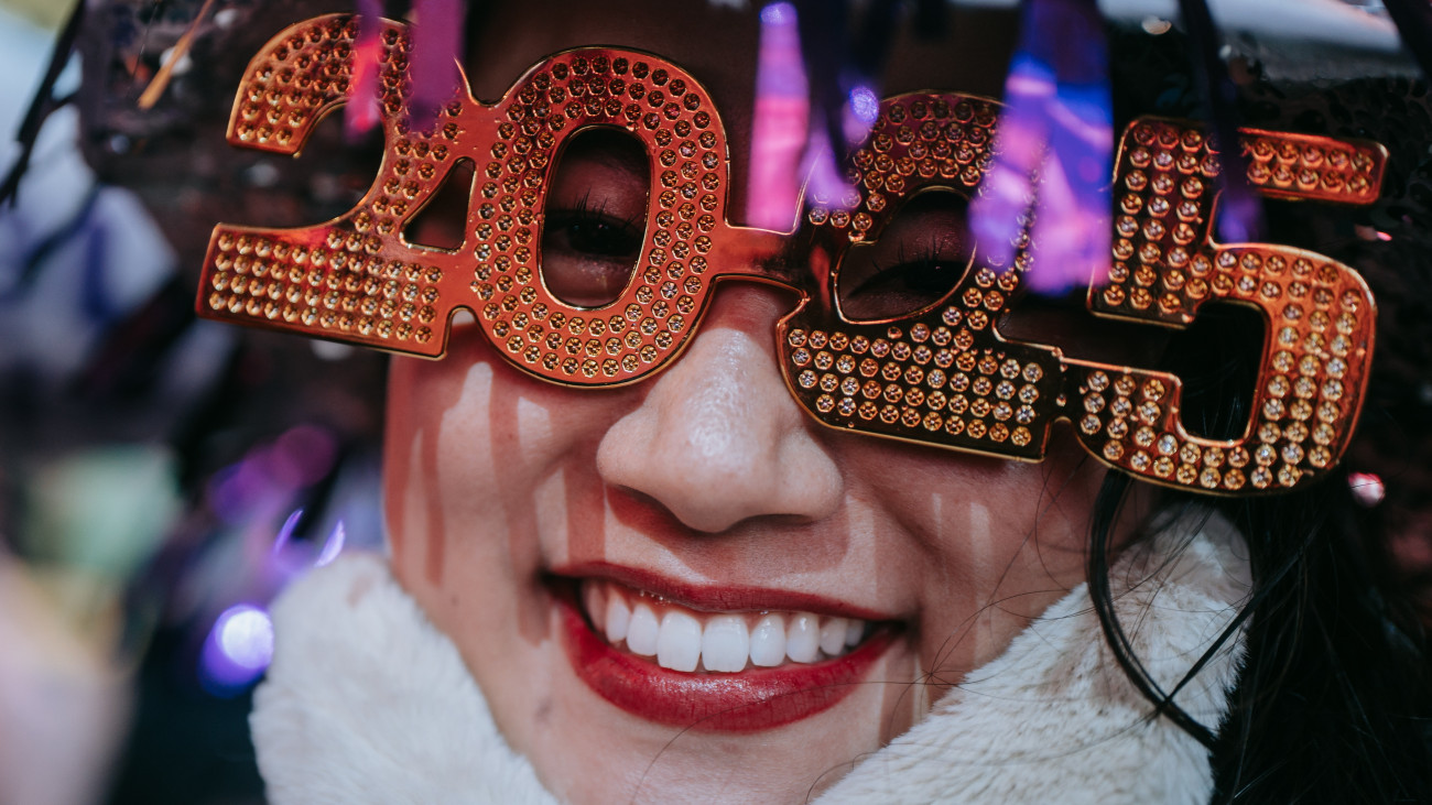 Az új év beköszöntét ünneplő nő a New York-i Times Square-en  2025. január 1-jén.