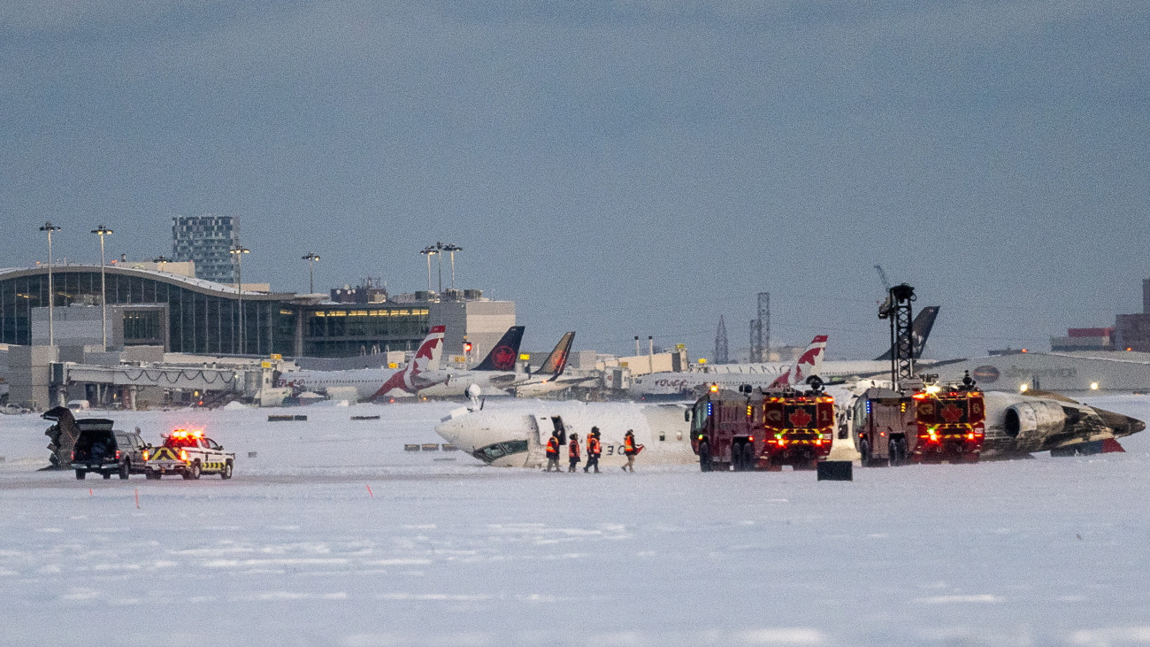 Mentőegységek a Delta Airlines amerikai légitársaság felborult utasszállító repülőgépénél a torontói Pearson Nemzetközi Repülőtéren 2025. február 17-én. A Minneapolisból érkező jármű leszállás közben megbillent, majd vélhetően széllökéstől a hátára fordult a csúszós kifutópályán, az egyik szárnya pedig leszakadt. A gépen 76 utas és 4 fős személyzet tartózkodott. Haláleset nem történt, 18-an megsérültek, többeket kórházba szállítottak.