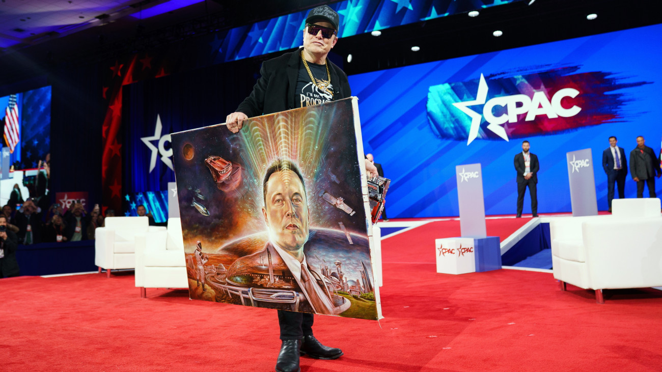 Elon Musk dél-afrikai-amerikai üzletember, az amerikai kormányzati hatékonyságért felelős adminisztratív testület (DOGE) vezetője ajándékba kapott önarcképet tart a Konzervatív Politikai Akció Konferencián (CPAC) a Maryland állambeli National Harborban 2025. február 20-án. A konferenciát évenként megrendezi az Amerikai Konzervatív Unió befolyásos republikánus, konzervatív politikusok és értelmiségiek részvételével.