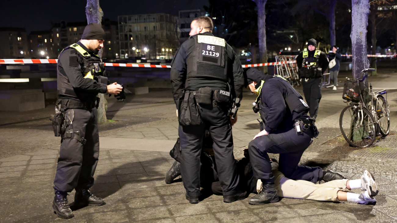 Rendőrök őrizetbe vesznek egy férfit a Berlin központjában található holokauszt-emlékműnél elkövetett késelés után 2025. február 21-én. A támadásban egy férfi súlyosan megsebesült, kórházba szállították.