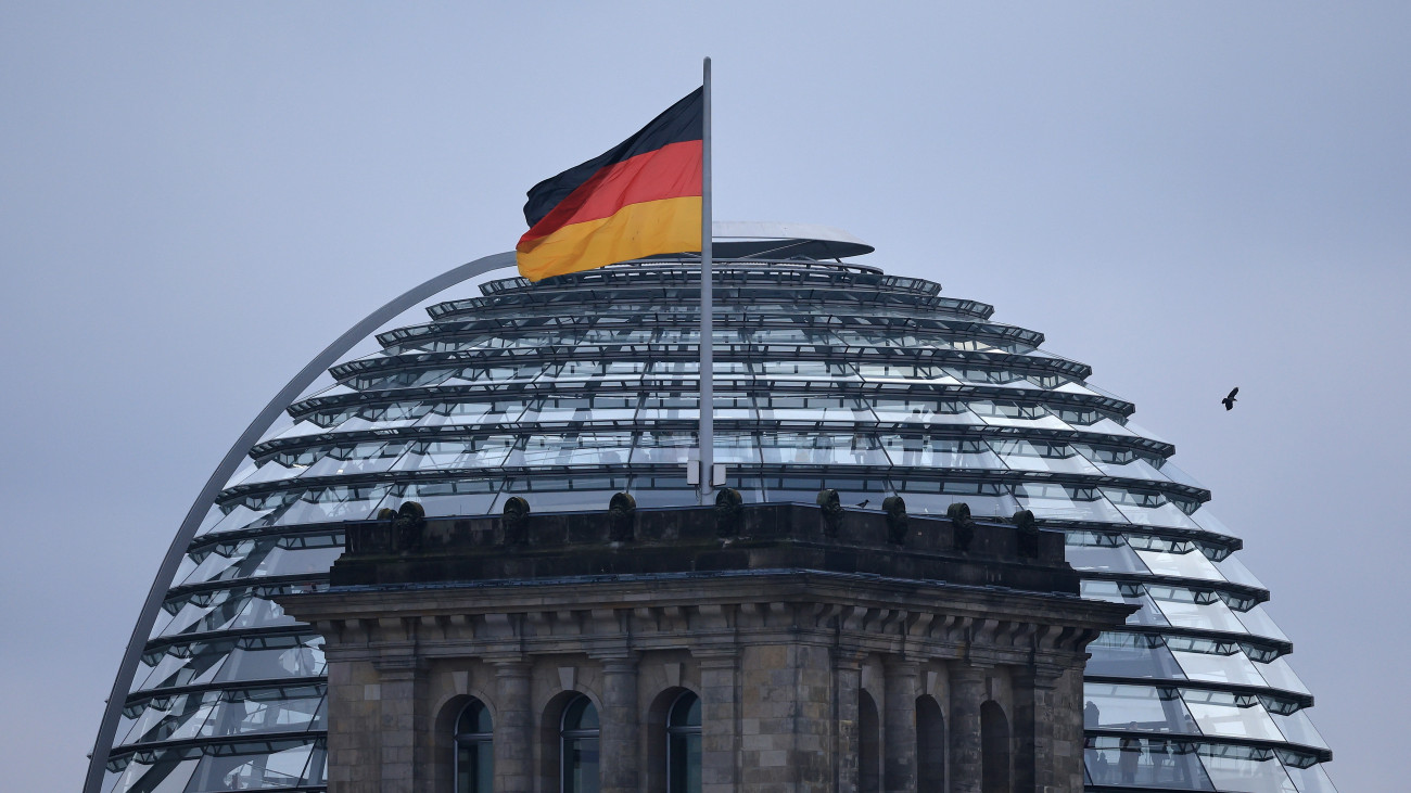 A német zászló lobog a német parlament épülete, a Reichstag tetején Berlinben az előrehozott szövetségi parlamenti választás napján, 2025. február 23-án.