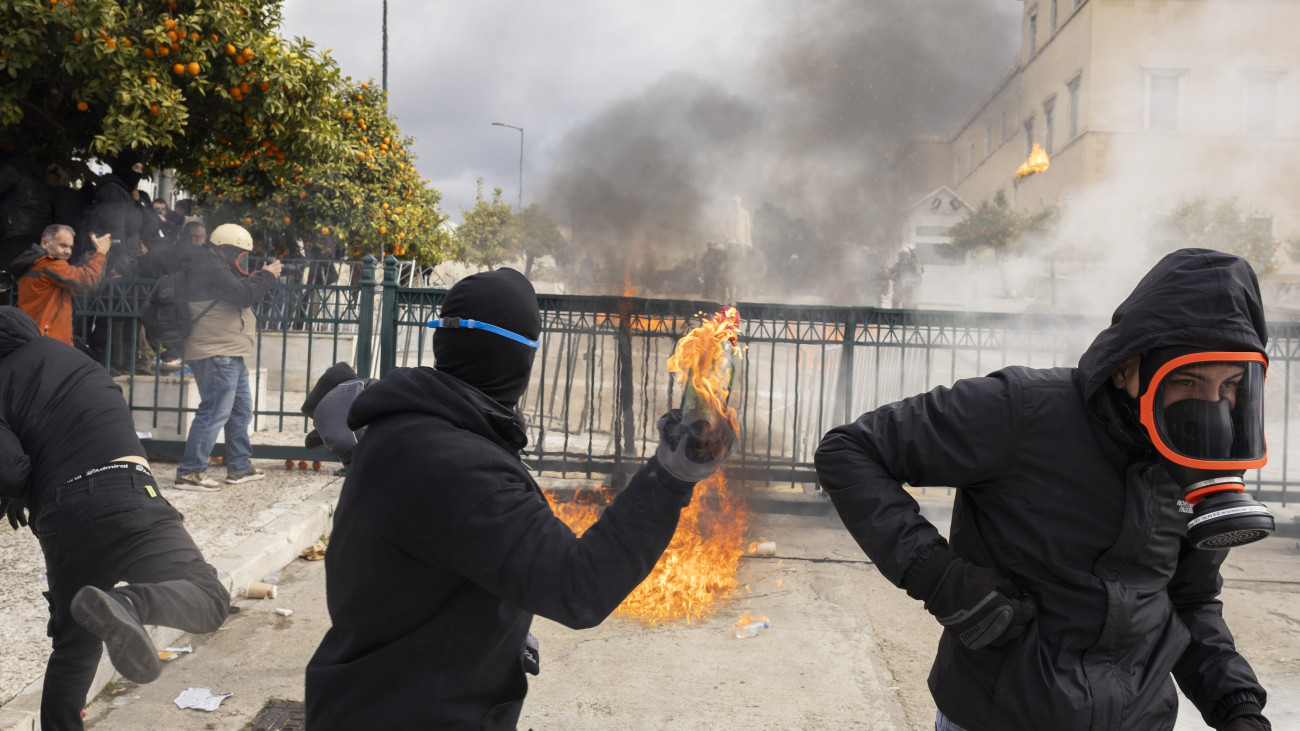 28 February 2025, Greece, Ath: Demonstrators throw incendiary devices at riot police outside the Greek parliament. Riots broke out in the Greek cities of Athens and Thessaloniki during large demonstrations to commemorate the serious train crash in Tempi two years ago. Photo: Socrates Baltagiannis/dpa (Photo by Socrates Baltagiannis/picture alliance via Getty Images)