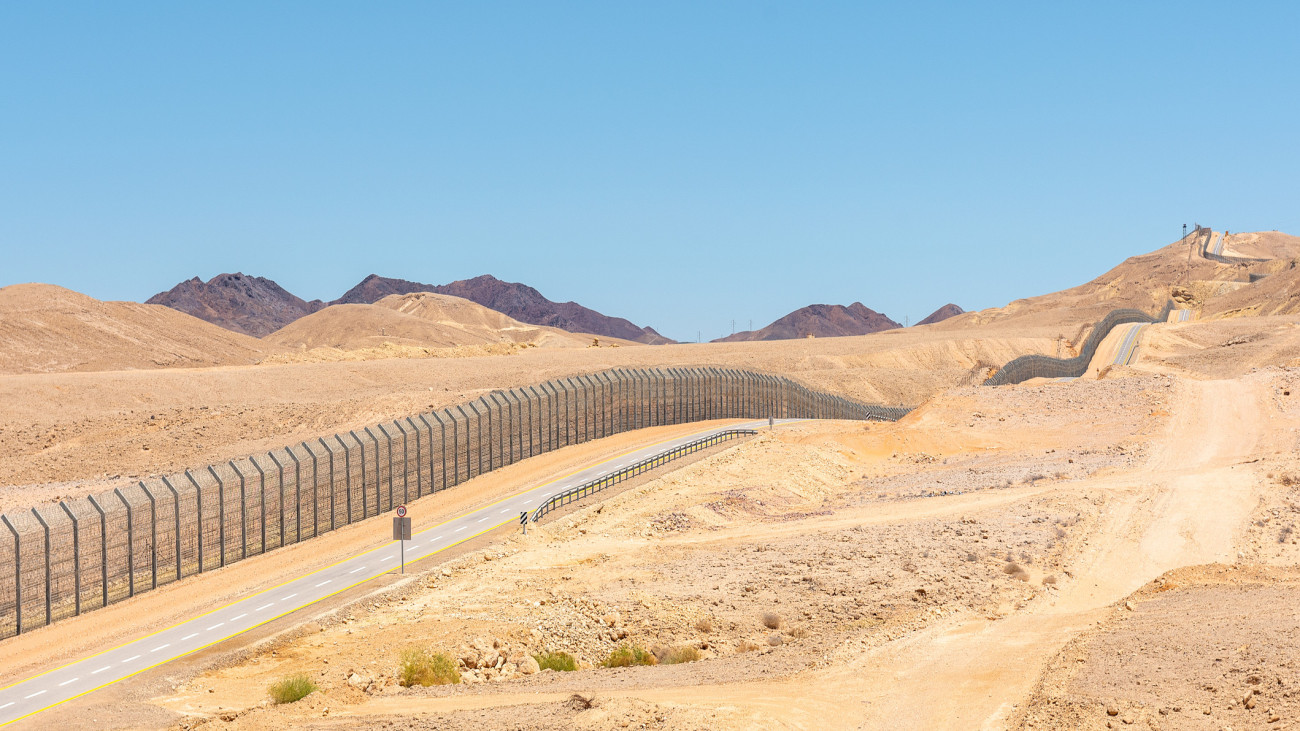 The new border fence between Israel Negev Desert and Egypt Sinai Desert with the patrol road protecting the border