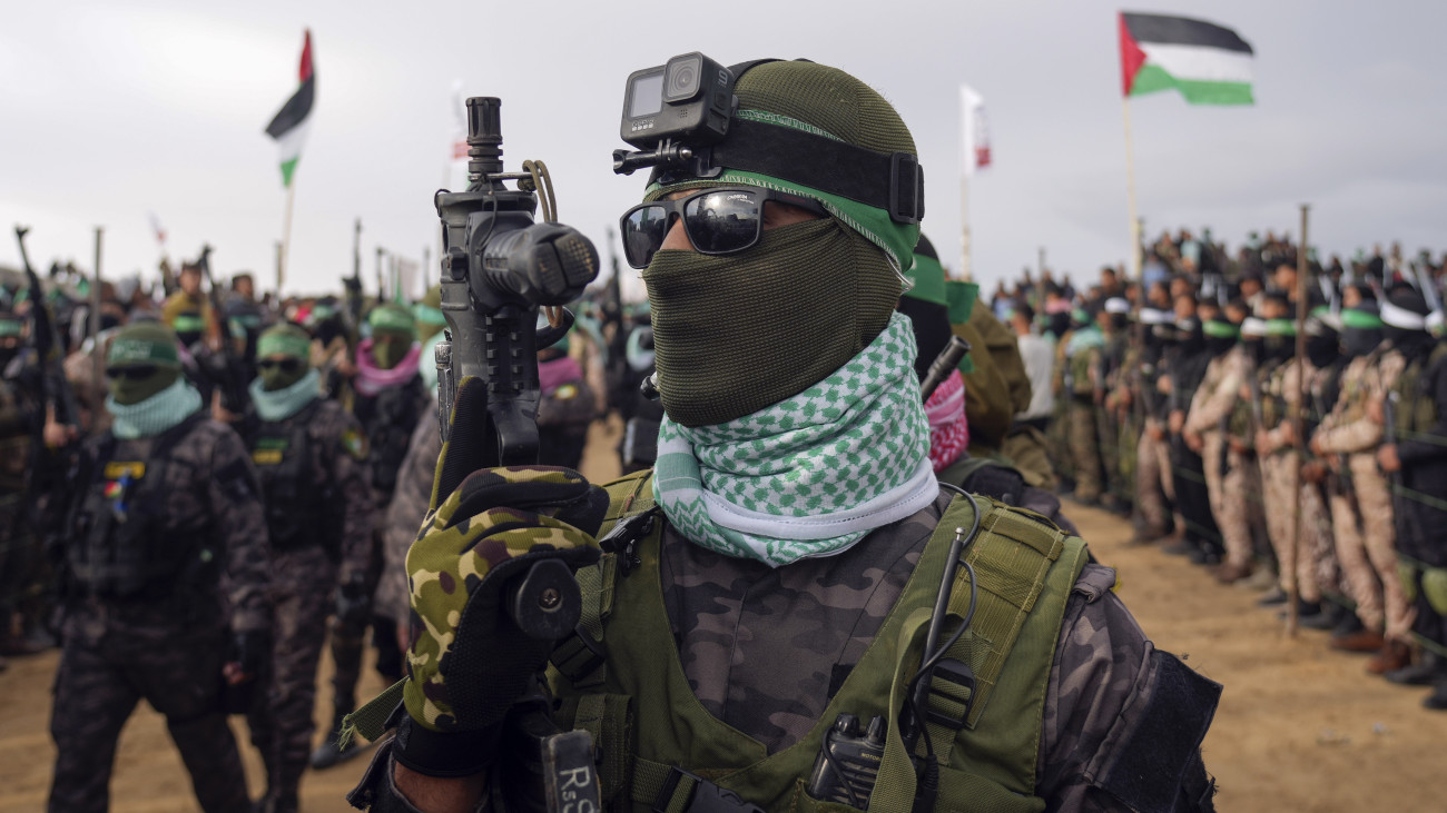 A Hamász palesztin iszlamista szervezet maszkot viselő fegyvereseinek egyike, mielőtt a négy halott izraeli túszt átadnák a Nemzetközi Vöröskereszt képviselőinek a Gázai övezet déli részén fekvő Hán-Júniszban 2025. február 20-án, a Hamász és az Izrael közötti tűzszüneti és túszalku megállapodás keretében. A Hamász a 2023. október 7-i terrortámadás jelképévé vált Bibasz család három tagjának, az édesanyának, Síri Bibasznak és két gyermekének, a kilenc hónaposan elrabolt Kfir Bibasznak, a négyévesen elvitt Ariel Bibasznak, valamint a 83 éves korában elhurcolt Oded Lifsic veterán újságíró, békeaktivistának a földi maradványait adta át. A terrorszervezet szerint a túszok izraeli légicsapásban vesztették életüket.