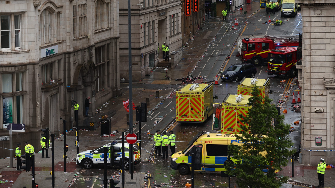 Rendőrök, mentősök és tűzoltók a liverpooli Liver Building közelében, ahol autó hajtott a Liverpool futballcsapatának bajnoki győzelmét ünneplő tömegbe az északnyugat-angliai nagyváros központjában 2025. május 26-án. A sofőrt a helyszínen őrizetbe vették.