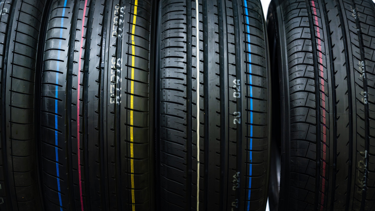 A detailed close-up of brand new car tires featuring distinct colored stripes. Perfect for automotive and transportation themes, highlighting durability and precision design.