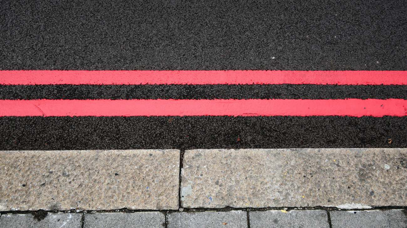 Photograph taken near to the St Pancras Station in London, UK. Two red lines : no stop and no parking allowed. Day light. Natural colors. Retouched photograph. 4:3 format.