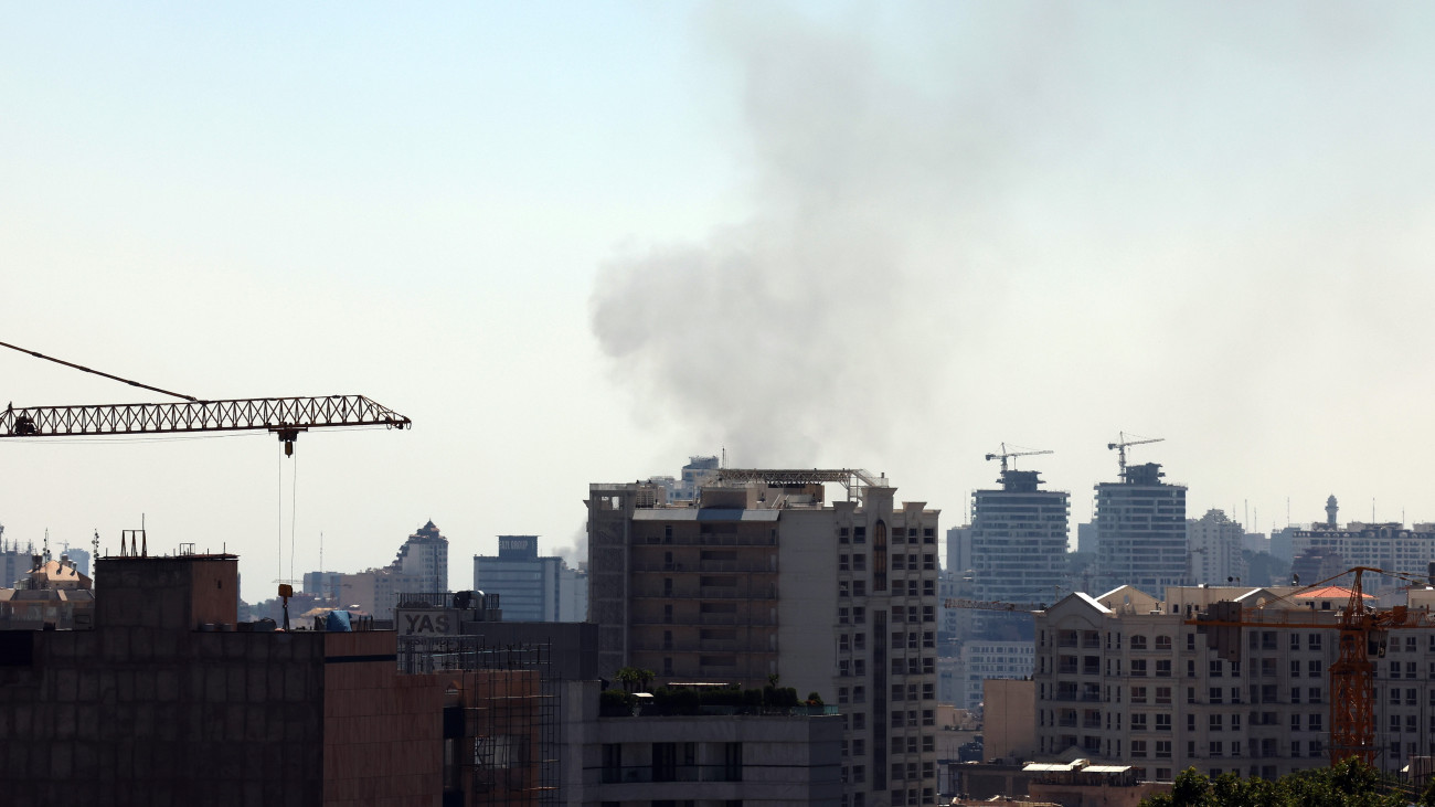 Izraeli légicsapás füstje Teherán felett 2025. június 17-én. Az izraeli vezetés június 13-ra virradóan nagyszabású légitámadás-sorozatot indított Irán ellen arra hivatkozva, hogy szerinte a síita állam túl közel jutott ahhoz, hogy atomfegyvert tudjon előállítani. Irán rakéta- és dróntámadásokkal válaszol az izraeli légicsapásokra, és ragaszkodik atomprogramjának folytatásához.