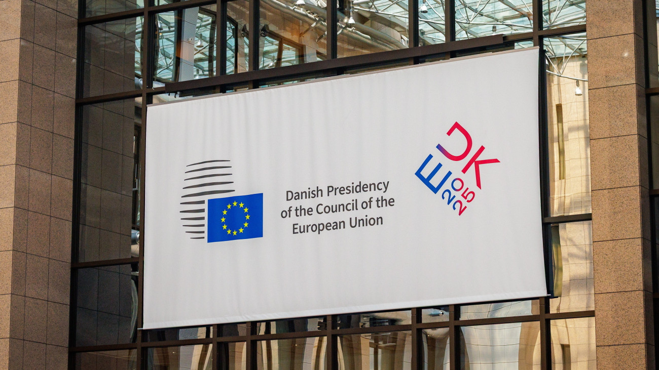 Az új dán uniós elnökség logója az Európai Tanács brüsszeli székházának aulájában 2025. július 1-jén, amikor Dánia átvette Lengyelországtól az Európai Unió Tanácsának hat hónapra szóló soros elnöki tisztét. Az Erős Európa a változó világban mottó alatt kezdődő dán EU-elnökség programjában a biztonság javítása, a versenyképesség erősítése, a zöld átmenet és az illegális migráció kezelése szerepel legfőbb célként, valamint az Ukrajna katonai és gazdasági támogatása melletti kiállás is.