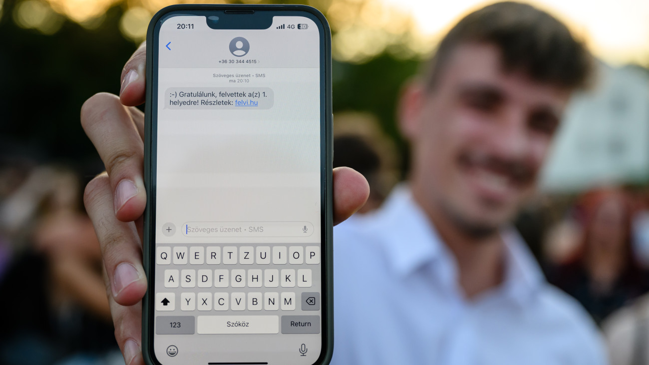 Felvételi értesítőjét mutatja telefonján egy fiatal Veszprémben, a Pannon Egyetem Pont Ott Partiján 2025. július 23-án.