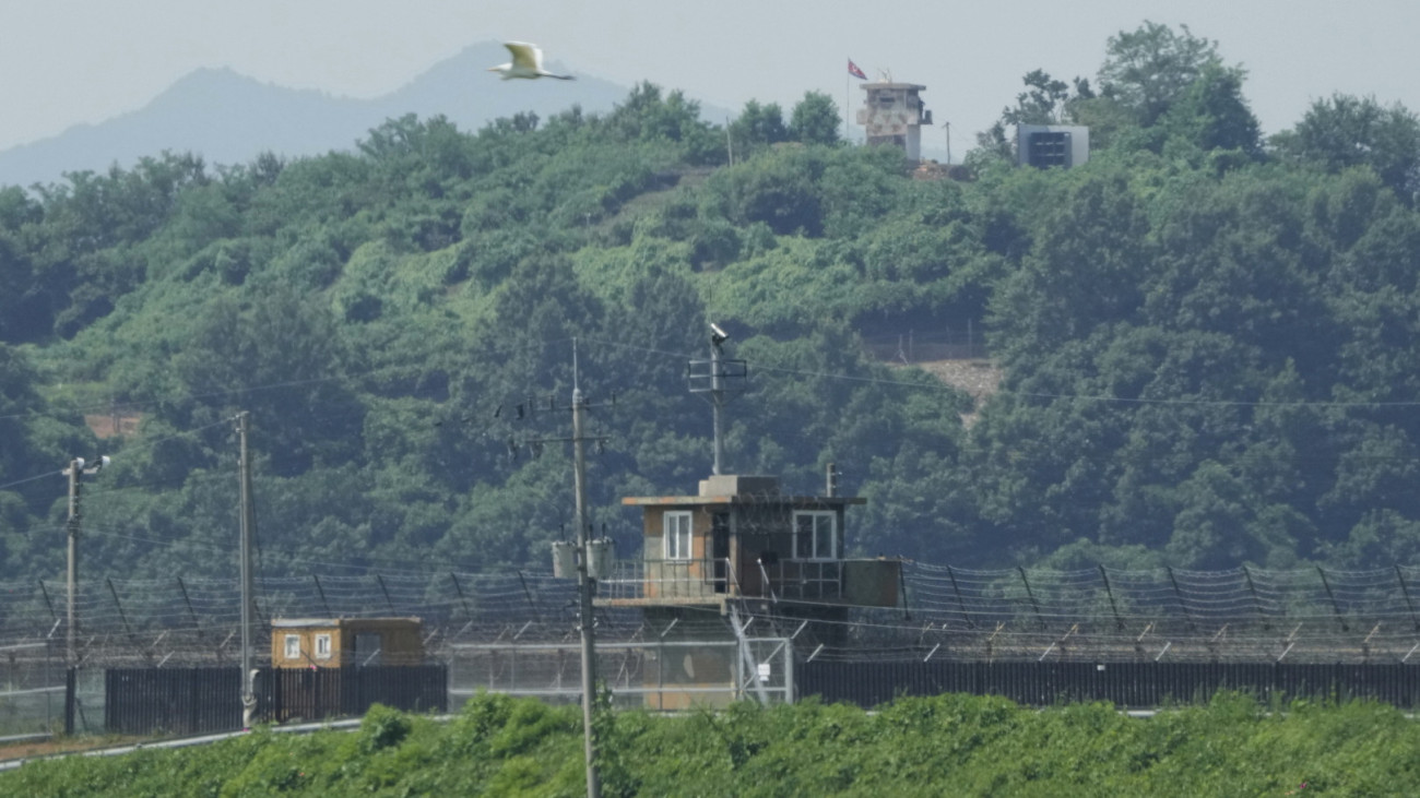 Észak-koreai őrtorony és hangszóró egy dél-koreai őrtoronnyal az előtérben a két Koreát elválasztó panmindzsoni demilitarizált övezetben fekvő Padzsuban 2025. augusztus 4-én. A dél-koreai védelmi minisztérium közlése szerint a mai napon elkezdték eltávolítani az Észak-Korea-ellenes rádióadásokat sugárzó hangszórókat az ország határáról.