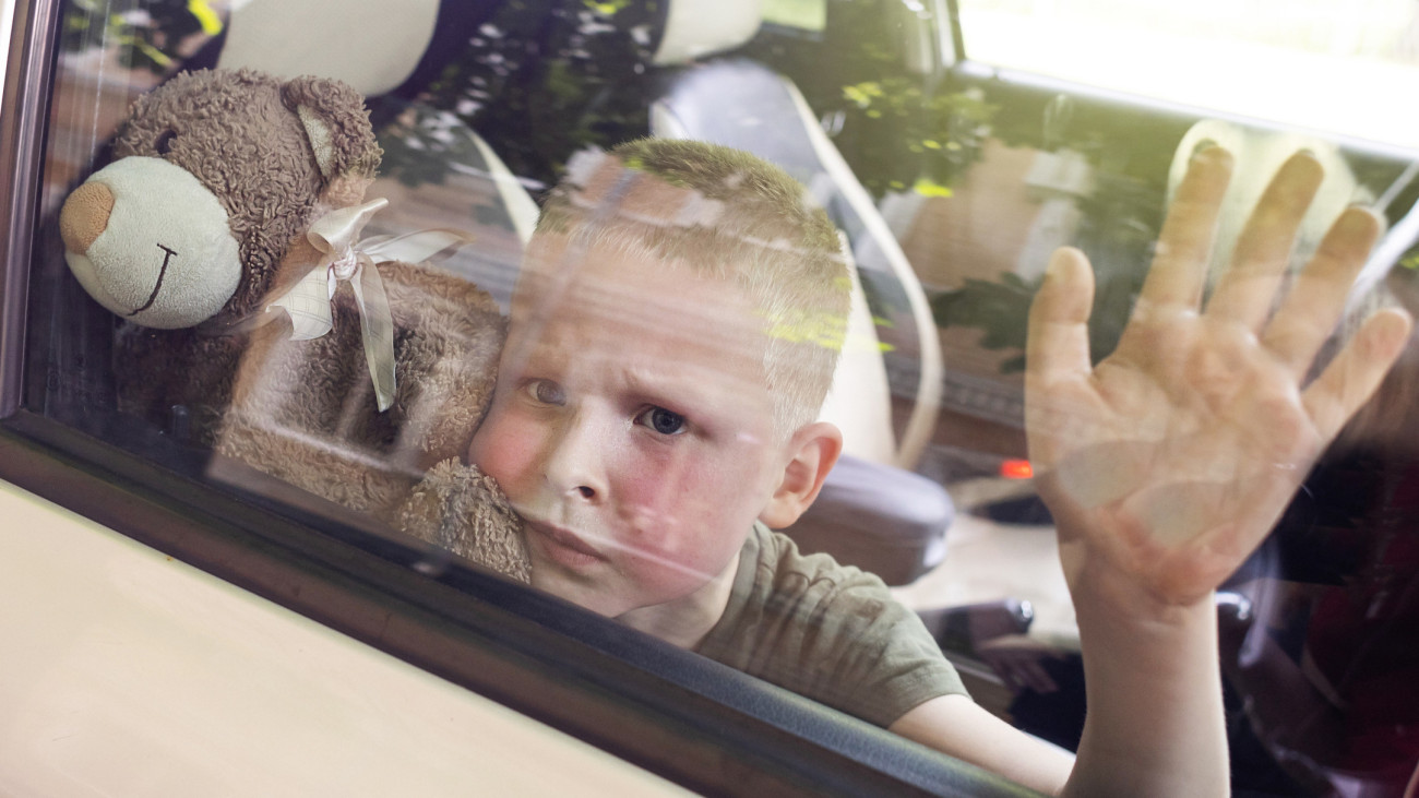 Blond boy is closed in auto without water. He is hot and his face is red. Irresponsible parents left the child alone in a hot car. Concept of poor care for kids. Child locked in car.