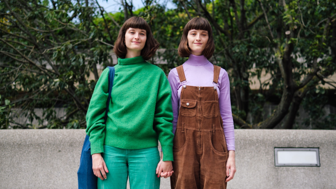 Side-by-side friends in colorful attire against an urban park scene