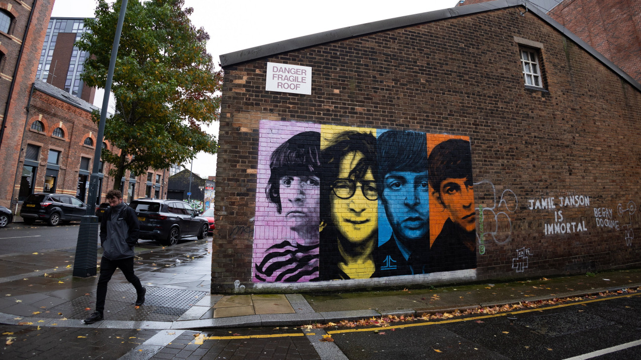 Ringo Starr, John Lennon, Paul McCartney és George Harrison, a Beatles egykori brit zenekar tagjainak portréi (b-j) egy liverpooli falfestményen 2023. november 2-án. A Beatles ezen a napon jelenteti meg a Now And Then című számukat, amelyet egy John Lennon által a 70-es években rögzített, eddig meg nem jelentetett demofelvételből nyertek ki a mesterséges intelligencia segítségével. Paul McCartney és Ringo Starr 2022-ben fejezte be a számot, amelyet még a 70-es években kezdett el Lennon egy demokazettára rögzítve. Lennon hangját a régi felvételről a mesterséges intelligencia segítségével nyerték ki és alkották újra, hogy fél évszázaddal a Beatles hivatalos feloszlása után méltó módon jelentethessék meg a dalt.