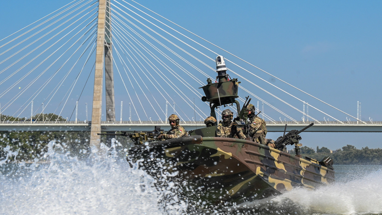 A honvédség egyik új Special Operations Craft - Riverine (SOC-R) különleges műveleti folyami naszádja a Dunán, a Megyeri híd előtt az átadás napján, 2025. augusztus 27-én. A SOC-R hajók képesek különleges műveleti csoportok vízi környezetben való kijuttatására és kiemelésére, akár tűz alatt is. Alkalmasak továbbá közvetlen tűztámogatásra, felderítési és hírszerzési feladatokra, utánpótlás és egészségügyi ellátmány célba juttatására, sebesültek evakuálására is.