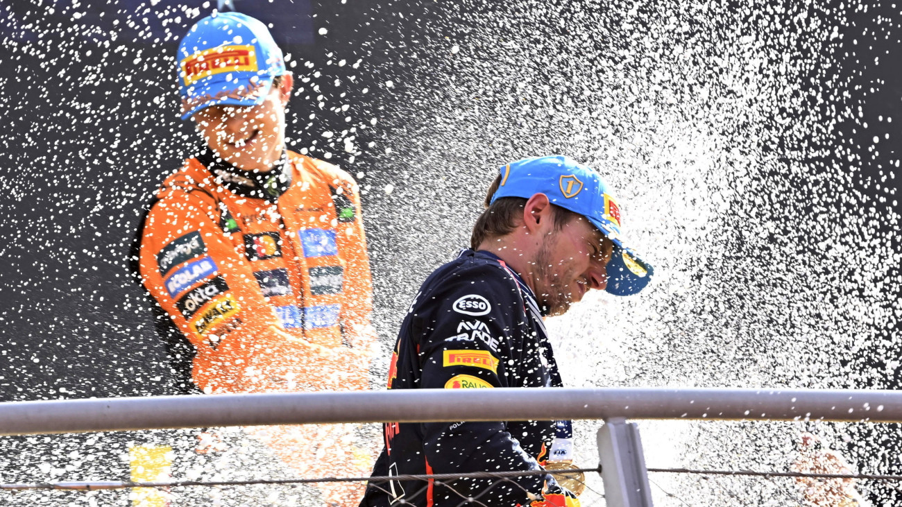 A futamgyőztes Max Verstappen, a Red Bull holland címvédője (elöl) és a harmadik helyezett Oscar Piastri, a McLaren ausztál versenyzője pezsgővel ünnepel a Forma-1-es autós gyorsasági világbajnokság Olasz Nagydíjának eredményhirdetésén a monzai versenypályán 2025. szeptember 7-én.