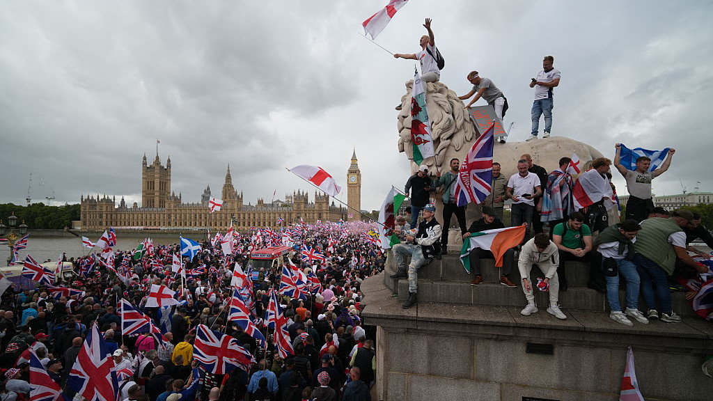 LONDON, ENGLAND - SEPTEMBER 13: Protesters wave Union Jack and St Georges England flags during the Unite The Kingdom rally on Westminster Bridge by the Houses of Parliament on September 13, 2025 in London, England. Far-right activist Tommy Robinson (also known as Stephen Yaxley-Lennon) has invited supporters to hold a rally in central London entitled Unite The Kingdom. The former English Defence League leader  and his supporters are actively islamaphobic and racist and have been behind much of the unrest seen outside hotels housing migrants this summer. Stand Up To Racism are mounting a counter-protest to todays rally. (Photo by Christopher Furlong/Getty Images)