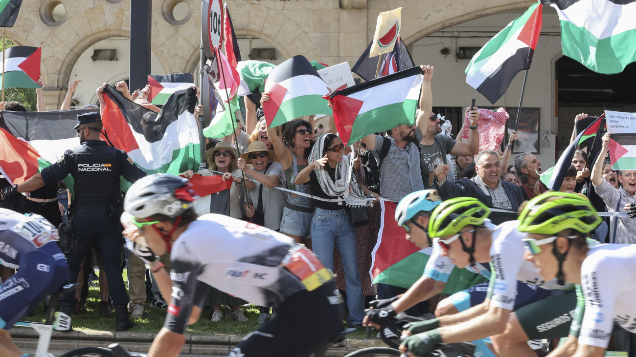 A  Gázai övezeti háború ellen tiltakoznak palesztin zászlót lengető tüntetők a Vuelta a Espana spanyol országúti kerékpáros körverseny 19., Rueda és Guijuelo közötti 161,9 kilométeres szakaszán Salamancában 2025. szeptember 12-én.