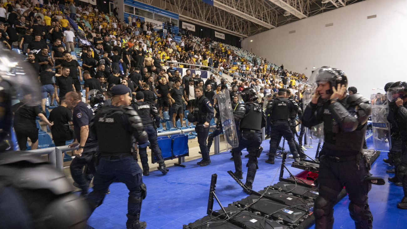 Rendőrök fékezik meg a román szurkolókat a férfi futsal Európa-bajnoki pótselejtezőben játszott Románia - Magyarország mérkőzésen a Sala Polivalenta din Craiova sportcsarnokban 2025. szeptember 24-én.