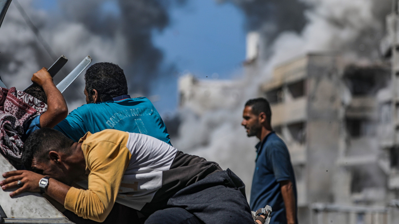 Fedezékbe bújó palesztinok, amikor izraeli rakéta csapódik be egy lakóépületbe Gázában 2025. szeptember 27-én.