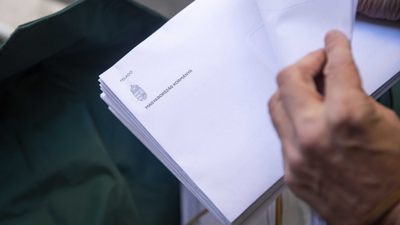 Az európai uniós szankciókról szóló nemzeti konzultáció kérdőíveit kézbesíti egy postás Budapesten 2022. október 14-én.