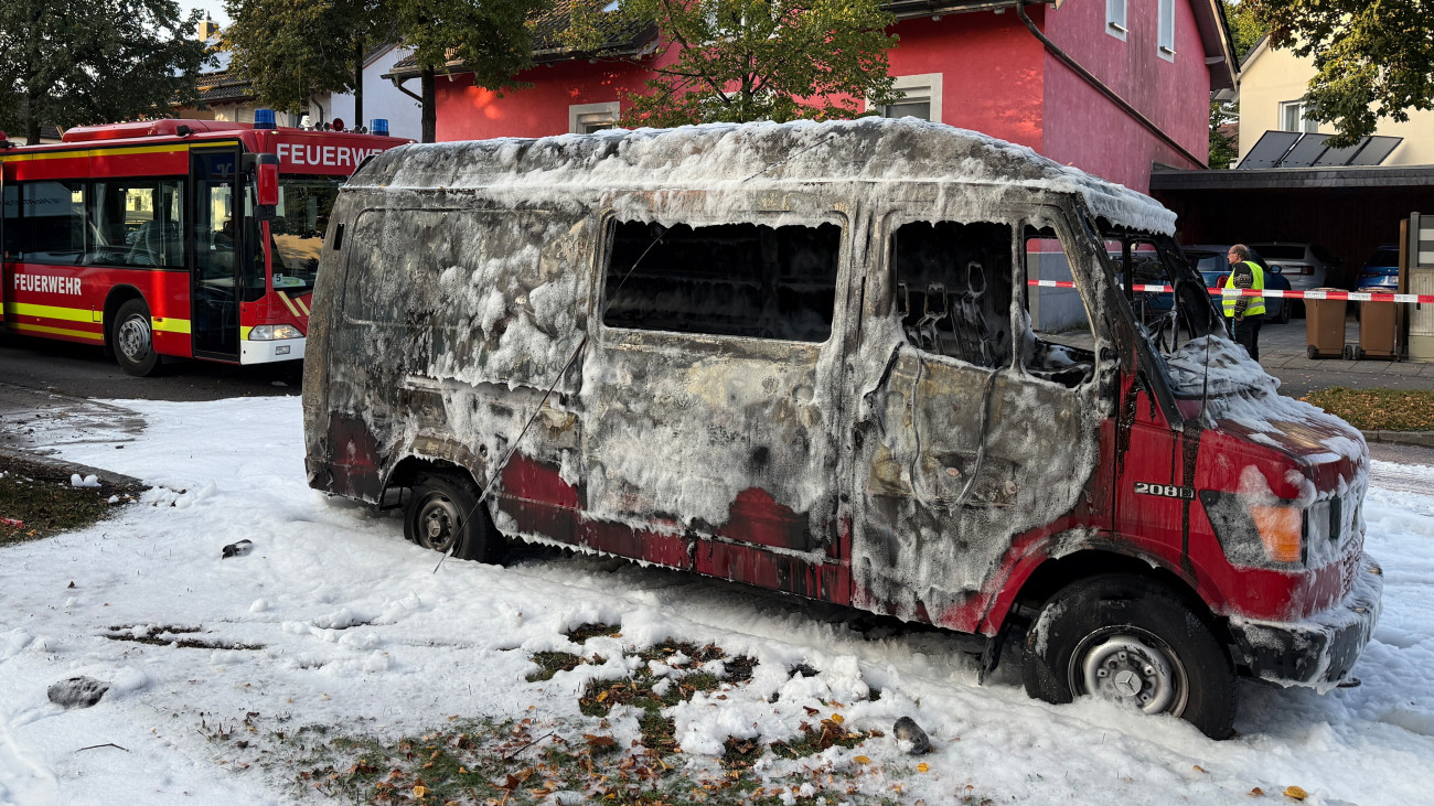 Tűzoltóhabbal borított, kiégett kisteherautó  München Lerchenau kerületében, ahol egy lángoló családi házhoz riasztották a tűzoltókat 2025. október 1-jén a hajnali órákban.