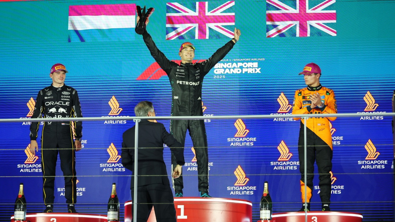 A második helyezett Max Verstappen, a Red Bull holland versenyzõje, a gyõztes George Russell, a Mercedes brit versenyzõje és a harmadik helyezett Lando Norris, a McLaren brit versenyzõje (b-j) a Forma-1-es autós gyorsasági világbajnokság Szingapúri Nagydíjának eredményhirdetésén a Marina Bay utcai pályán 2025. október 5-én.