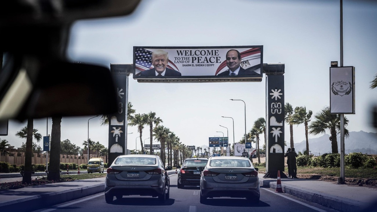 Donald Trump plakáton, alatta autók haladnak.