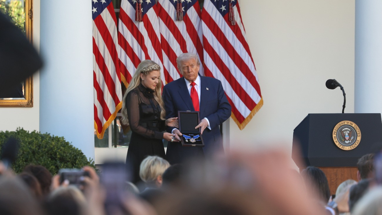 Erika Kirk, Charlie Kirk amerikai konzervatív aktivista özvegye átveszi a férjének posztumusz odaítélt Elnöki Szabadság Érdemrendet, a legmagasabb amerikai polgári kitüntetést Donald Trump amerikai elnöktõl a washingtoni Fehér Ház rózsakertjében tartott ünnepségen 2025. október 14-én. Kirk az elõzõ hónapban politikai gyilkosság áldozatául esett.