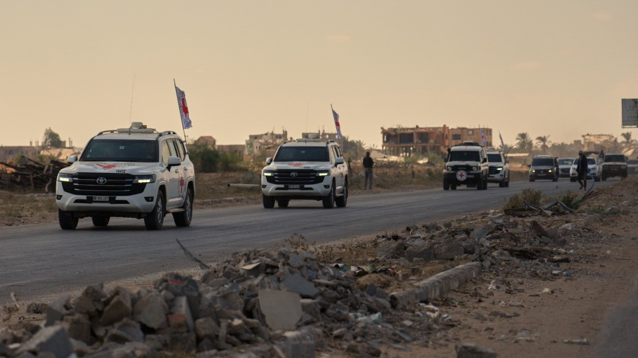 A Nemzetközi Vöröskereszt Izraelbõl elrabolt túszokat szállító autói az izraeli határhoz tartanak a Gázai övezet déli részén fekvõ Hán Júniszból 2025. október 13-án. Az Izrael és a Hamász palesztin iszlamista szervezet megállapodása szerint a Hamász ezen a napon visszaadja az általa 2023. október 7-én elrabolt izraeli túszok utolsó csoportját, Izrael pedig szabadon enged csaknem kétezer palesztin foglyot.