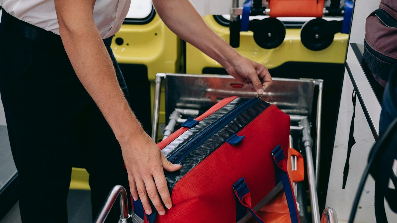 Mentőstiszt a mentőautóban elsősegély-felszereléssel és hordággyal.