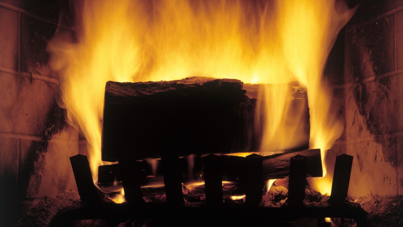 Tűzifa lángol egy kandallóban.