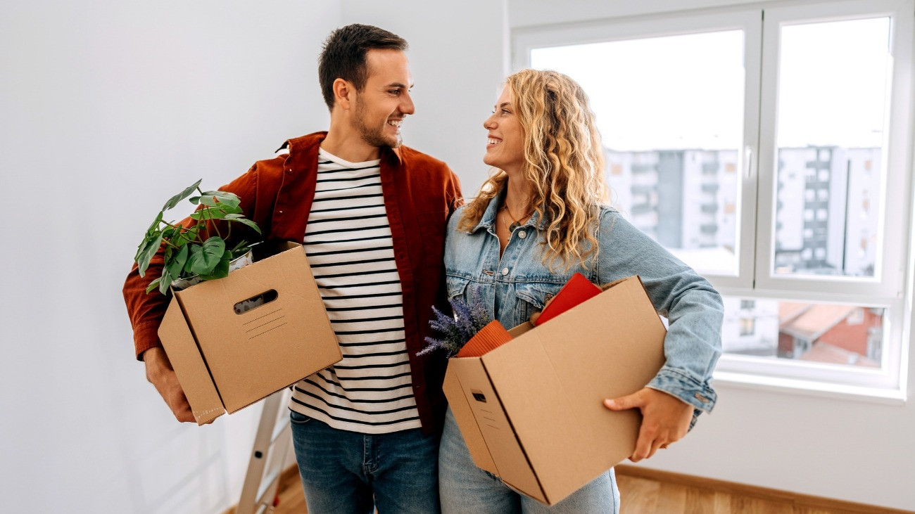 Férfi és nő egy üres szobában beköltözés előtt, dobozokkal