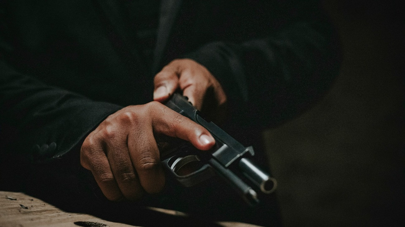 Egy ember éppen felhúz egy öntöltő pisztolyt.