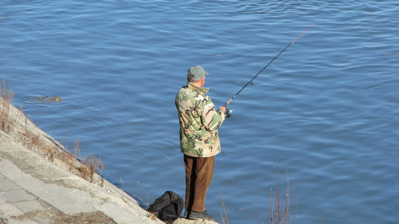 Folyóparton horgászik egy férfi.