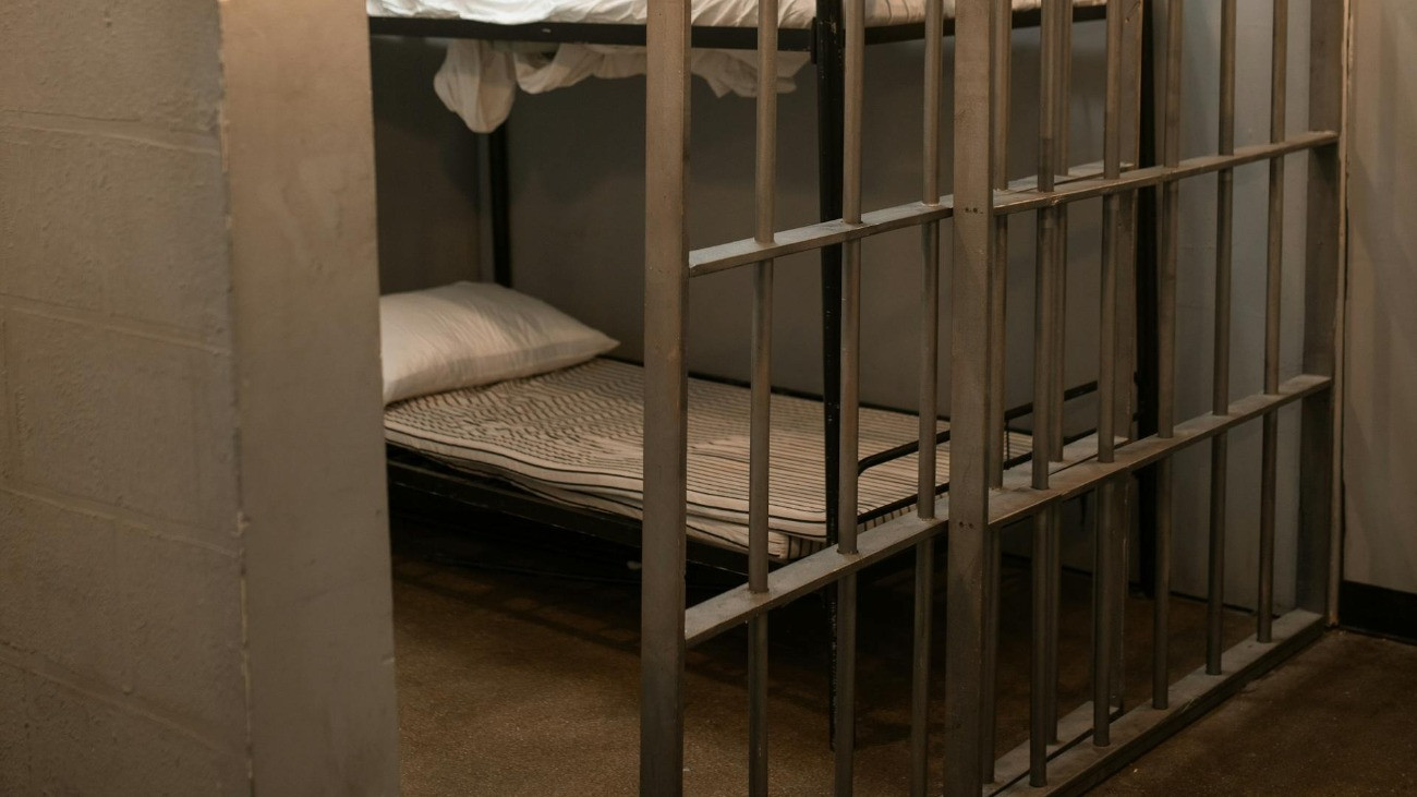 Egy börtöncella nyitott ráccsal, emeletes ággyal.