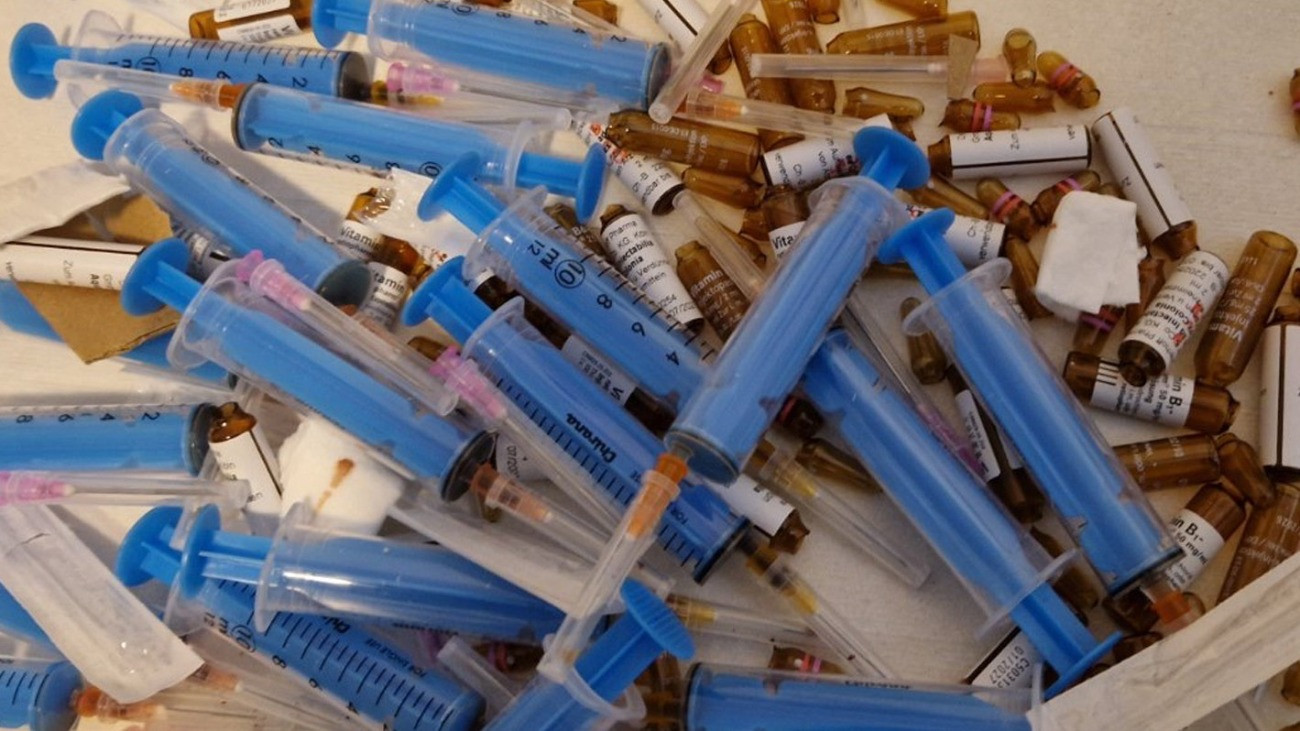 Rendőrségi fénykép a lefoglalt ampullákról és injekciós tűkről.