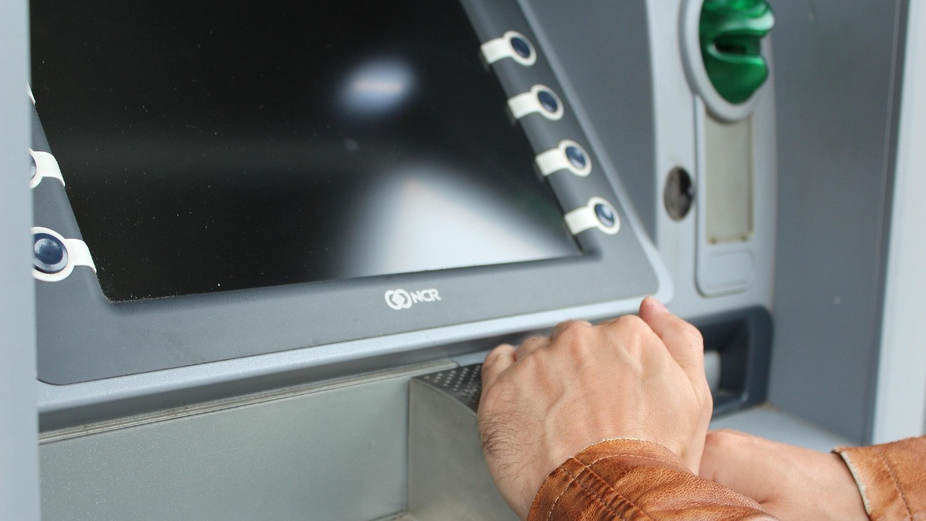Egy férfi megadja PIN-kódját egy ATM-nél, a művelet során bal kezével eltakarja a számokat.