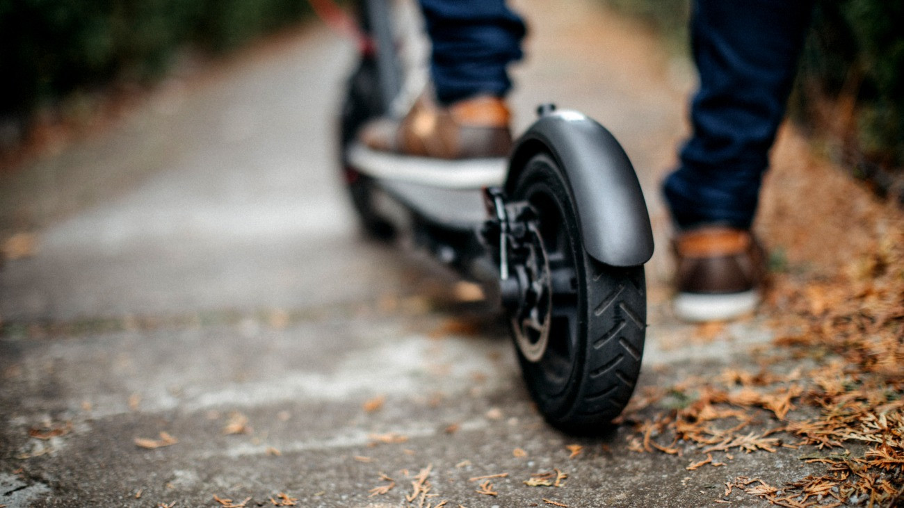 Elektromos rolleres várakozik az utcán.