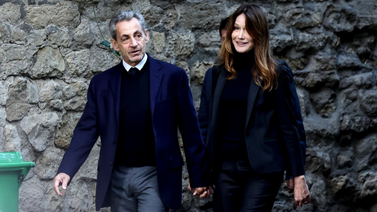 Nicolas Sarkozy volt francia elnök felesége, Carla Bruni-Sarkozy társaságában indul otthonából a párizsi Santé börtönbe 2025. október 21-én, börtönbüntetése megkezdésének napján. A 70 éves Sarkozyt a 2007-es gyõztes elnökválasztási kampánya törvénytelen líbiai finanszírozásának gyanúja miatt indított perben ítélték öt év szabadságvesztésre szeptember 25-én.