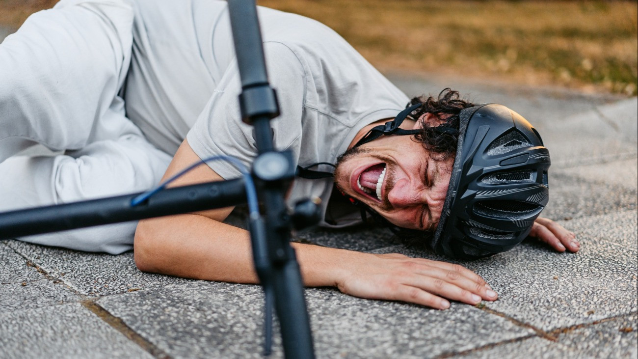 Mid-adult man falling from an electric scooter on the quayside.