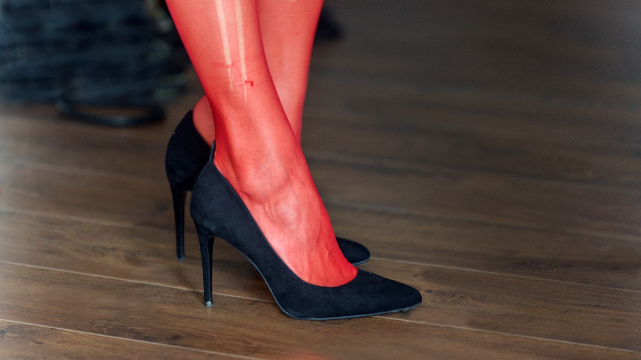 Szakadt piros harisnyát és tűsarkút viselő hölgy.