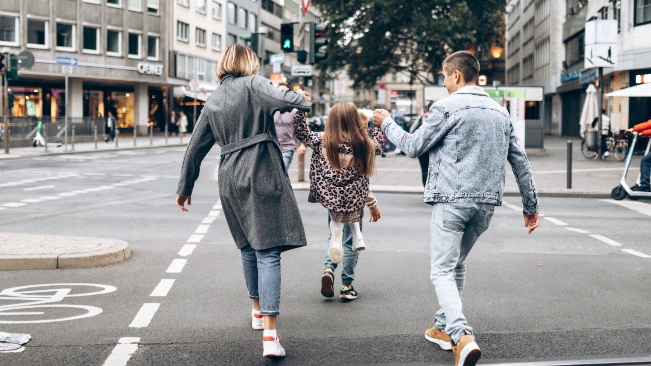 Kétgyermekes család sétál egy városban.