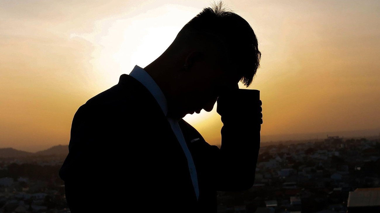 gondterhelt férfi árnyéka naplemente előtt